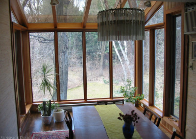 A lean-to sunroom increases the footprint of a residential dining area by extending away from the home