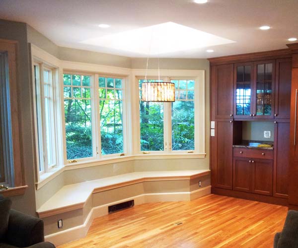 The tray ceiling, light accent, and tall windows introduce abundant levels of natural sunlight into this kitchen area